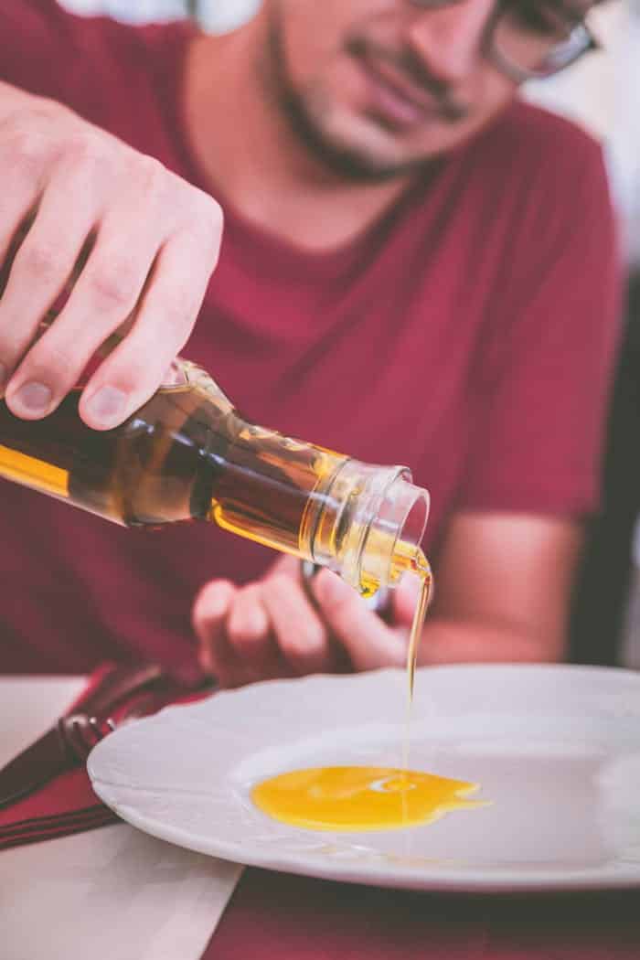 pouring extra vergin olive oil - podere treggiaia